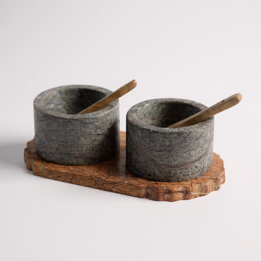 Selvada marble dual pinch pot set on live-edge acacia tray with wooden spoons — angled hero shot showing dark mottled stone