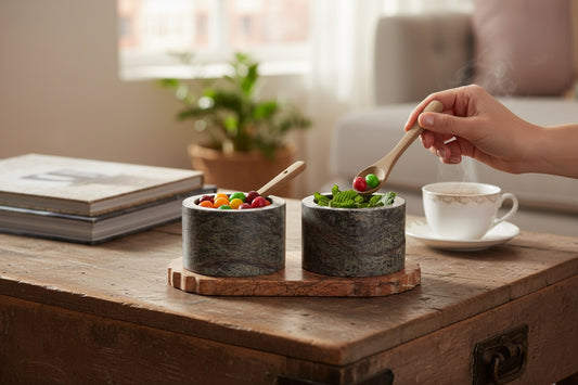 Selvada marble pinch pot set in use — hand using wooden spoon from cups filled with candy on rustic wooden chest, lifestyle shot