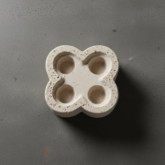 Travertine four-well candle holder — top view showing four carved tea light wells in clover silhouette